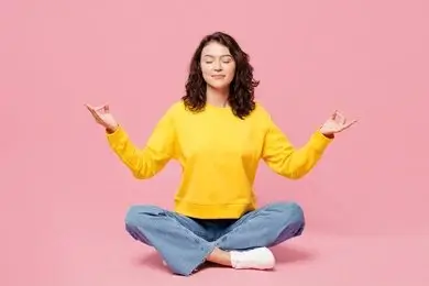 Woman practicing restorative yoga pose on a mat for hormonal balance and stress relief